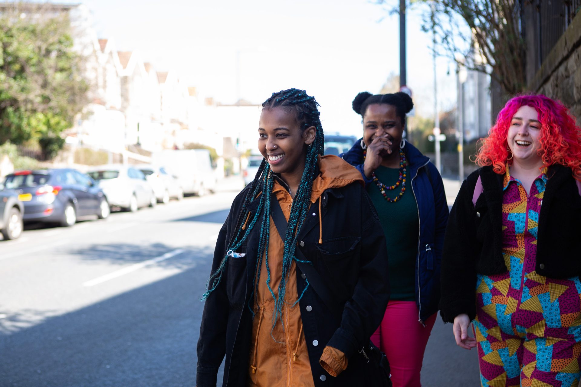 People laughing, smiling and walking down the street together